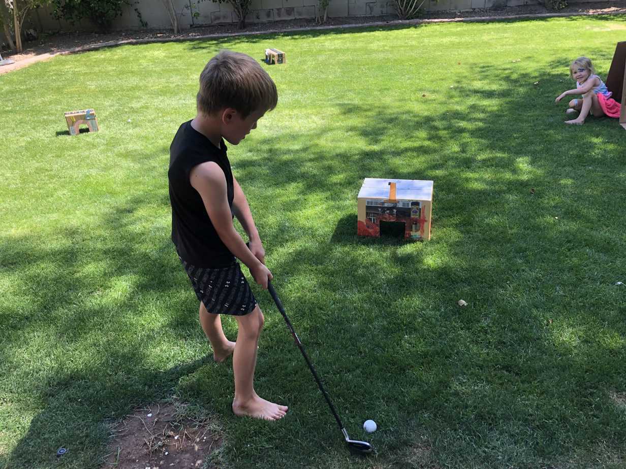 Boy playing mini golf