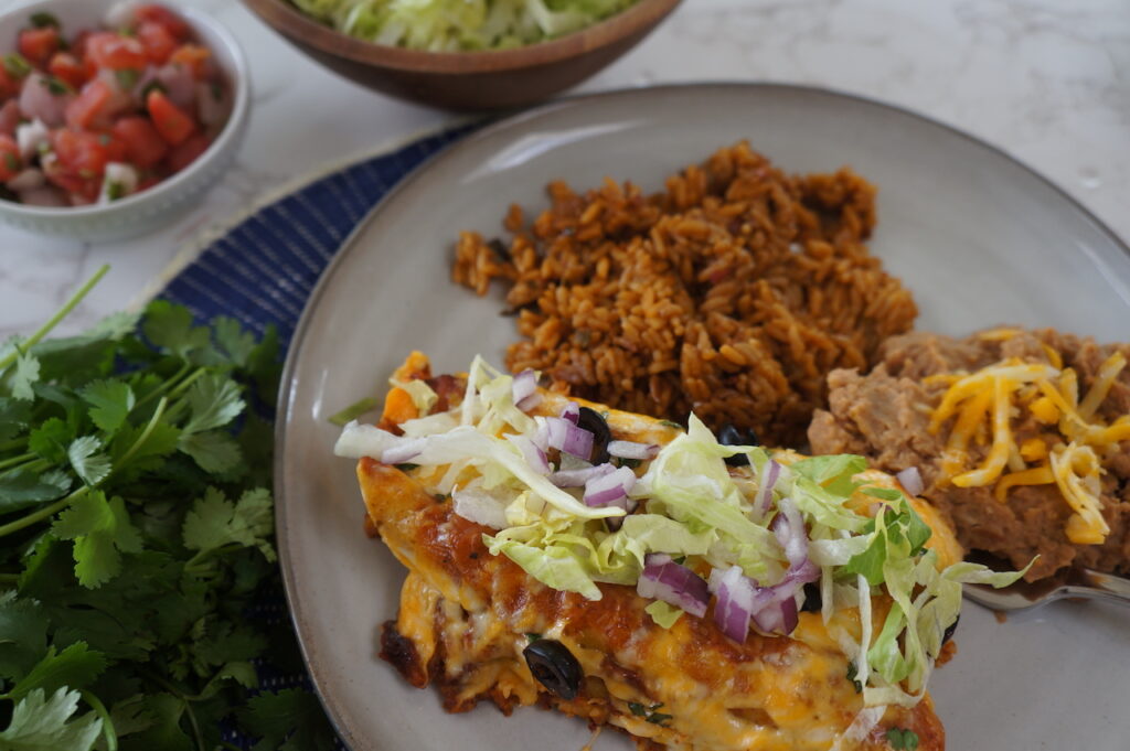 Taquitos Enchiladas with beans and rice.