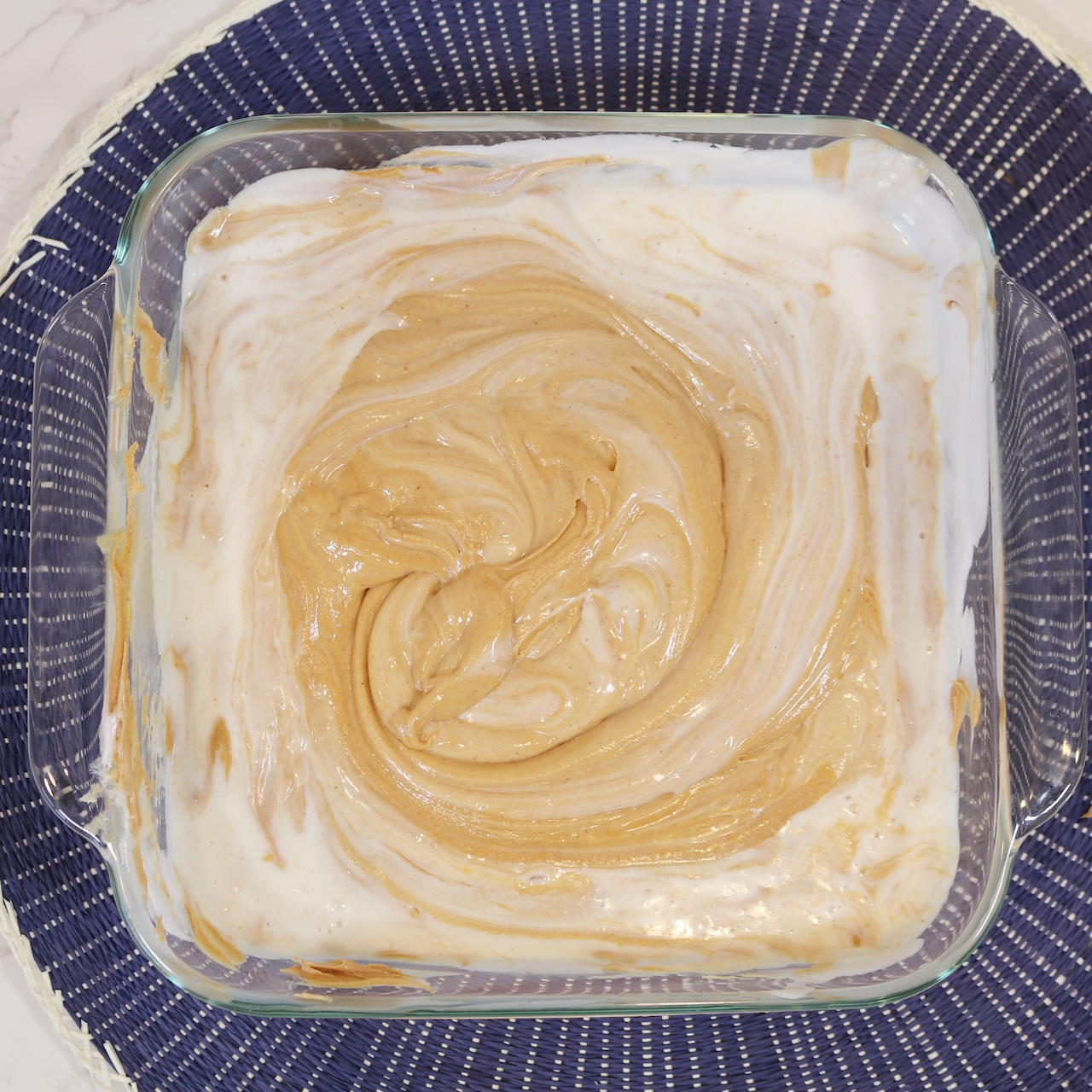 Peanut butter and frosting mixed together in glass dish