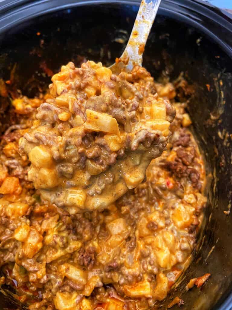 Taco Potato Casserole in crockpot with spoon