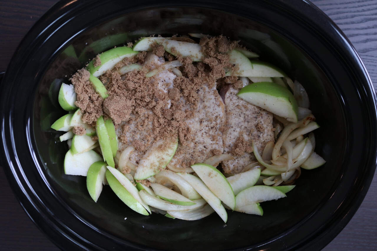 Pork Chops with sliced apples, onions and brown sugar in crockpot