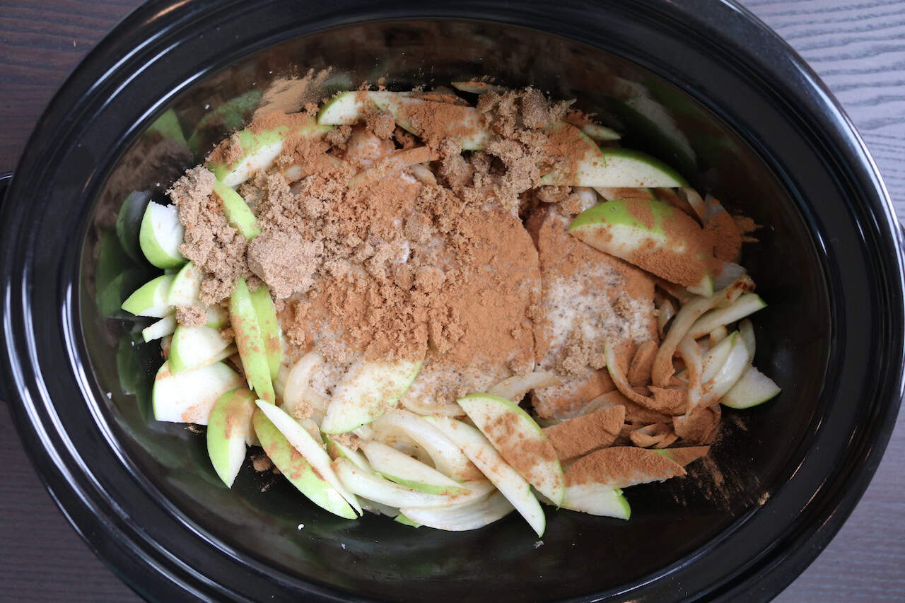 Pork Chops with sliced apples, onions, cinnamon and brown sugar in crockpot