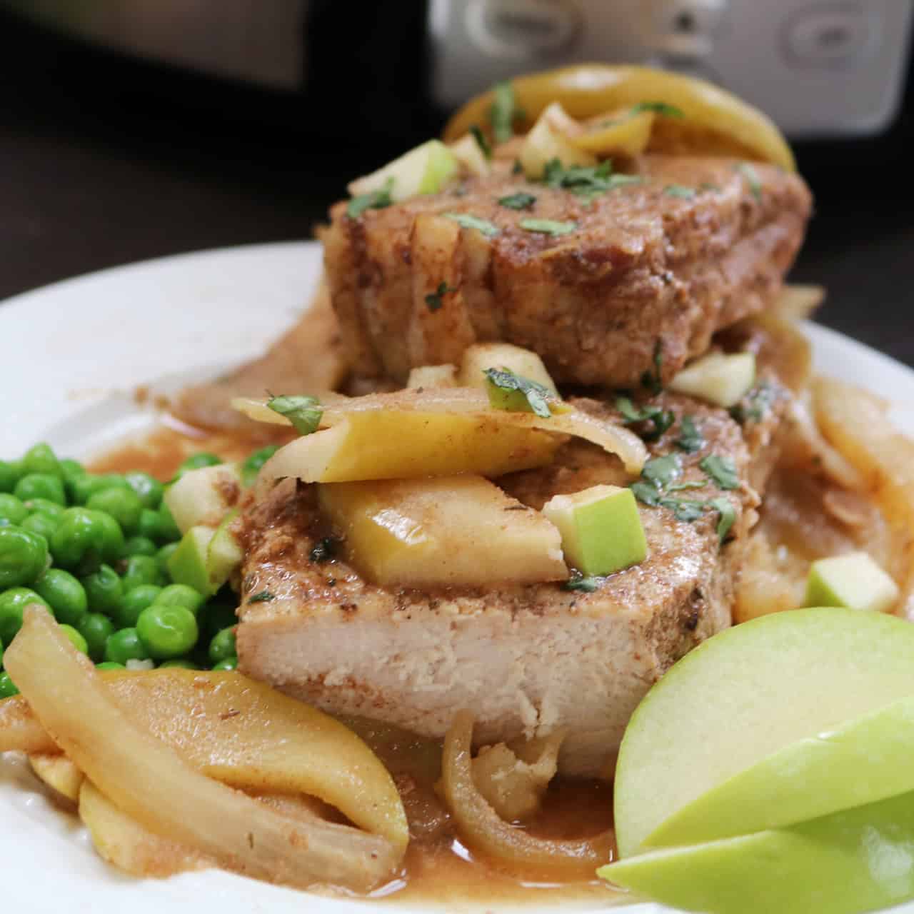 Slow Cooker Pork Chops with Apples on plate with peas