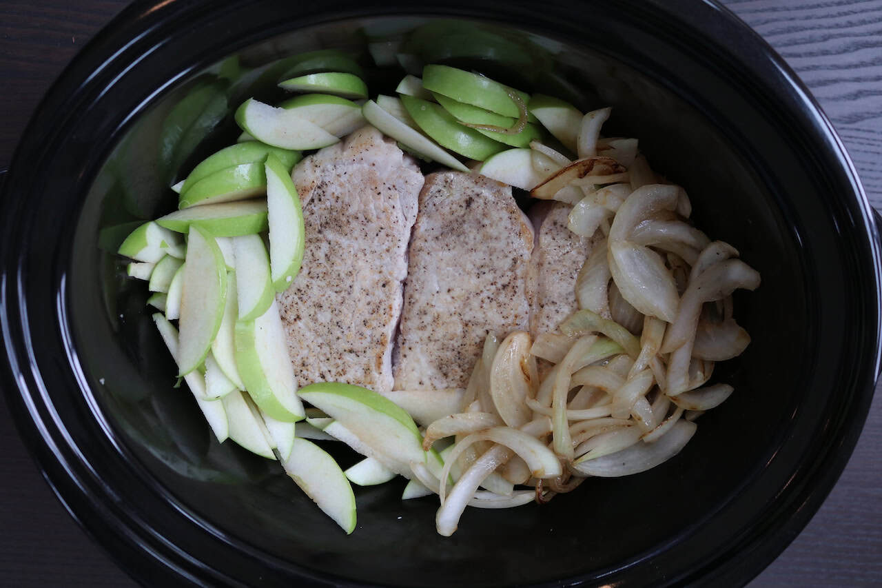 Apple Pork Chops with sliced apples and onions in crockpot