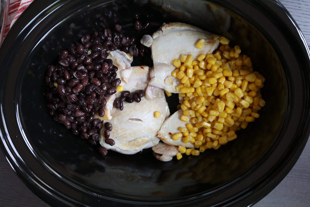 Chicken Thighs, corn and black beans in crockpot.