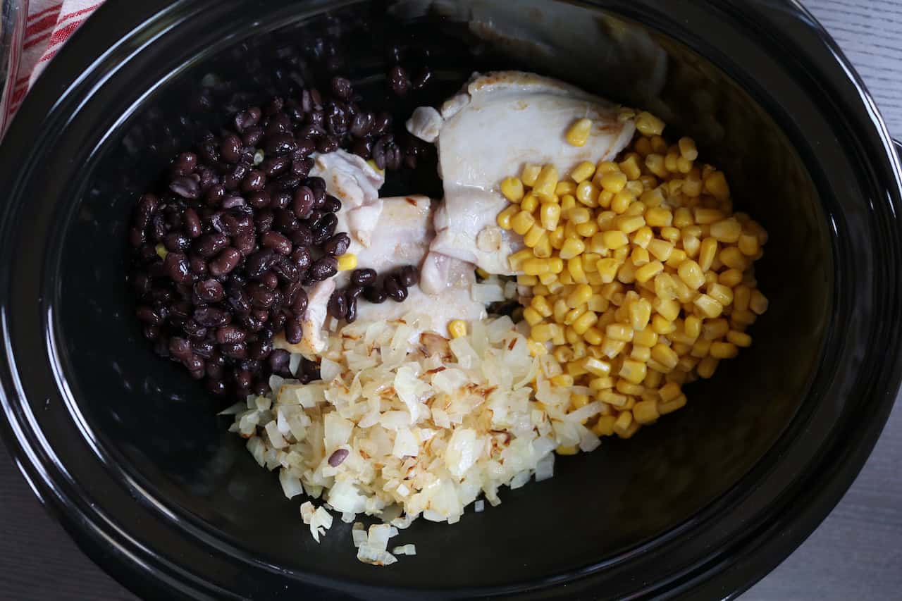 Chicken Thighs, corn, onions, and black beans in crockpot.