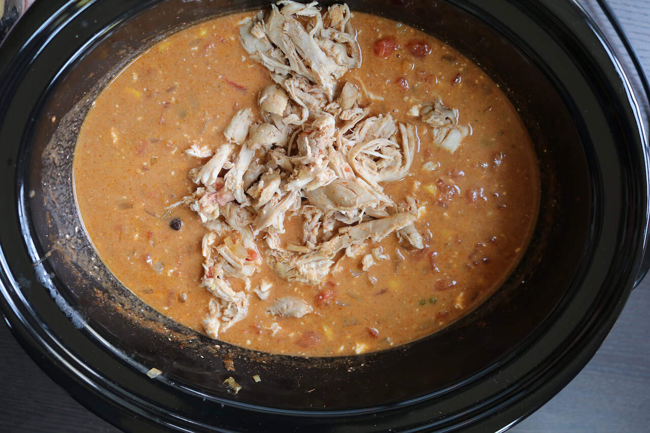 Shredded chicken on top of soup.