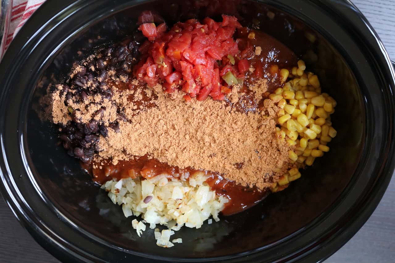 Chicken Thighs, corn, onions, Rotel Tomatoes, enchilada Sauce, taco seasoning and black beans in crockpot.