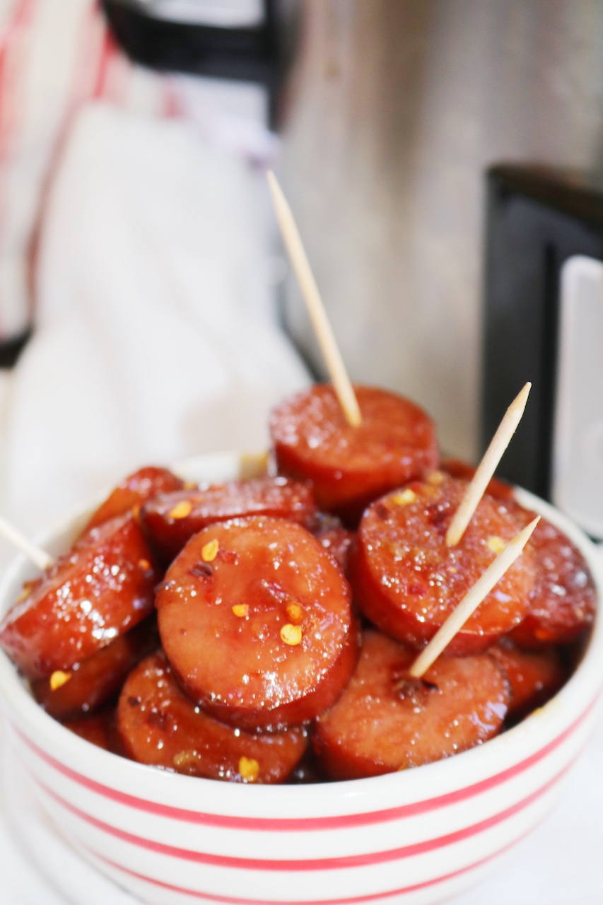 Kielbasa Appetizer Recipe in red striped bowl with toothpicks.